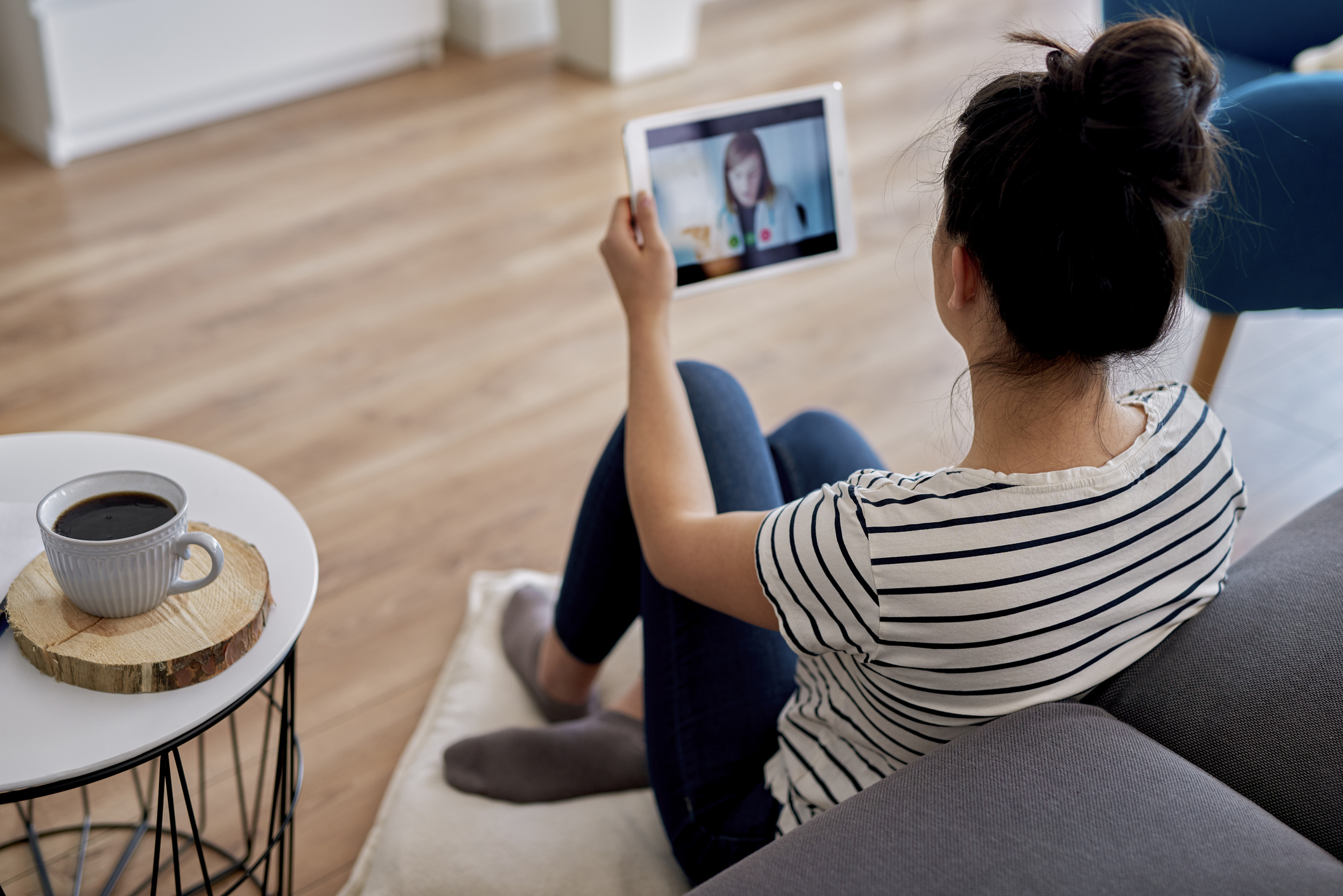 Woman talking to doctor through tablet