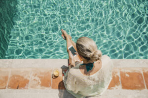 Deals of the Week: woman on mobile phone near pool