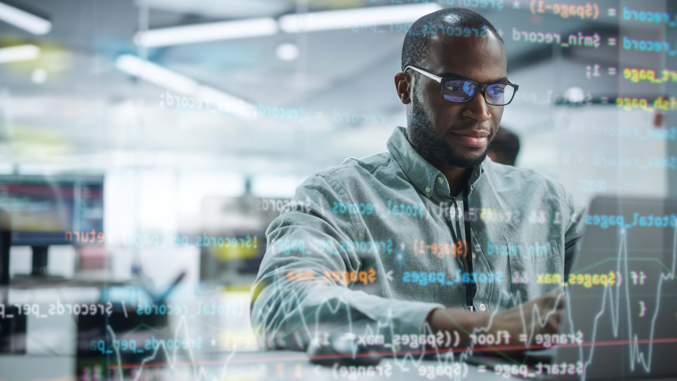 Data scaling start-up concept. Young black programmer with running code superimposed over him at work